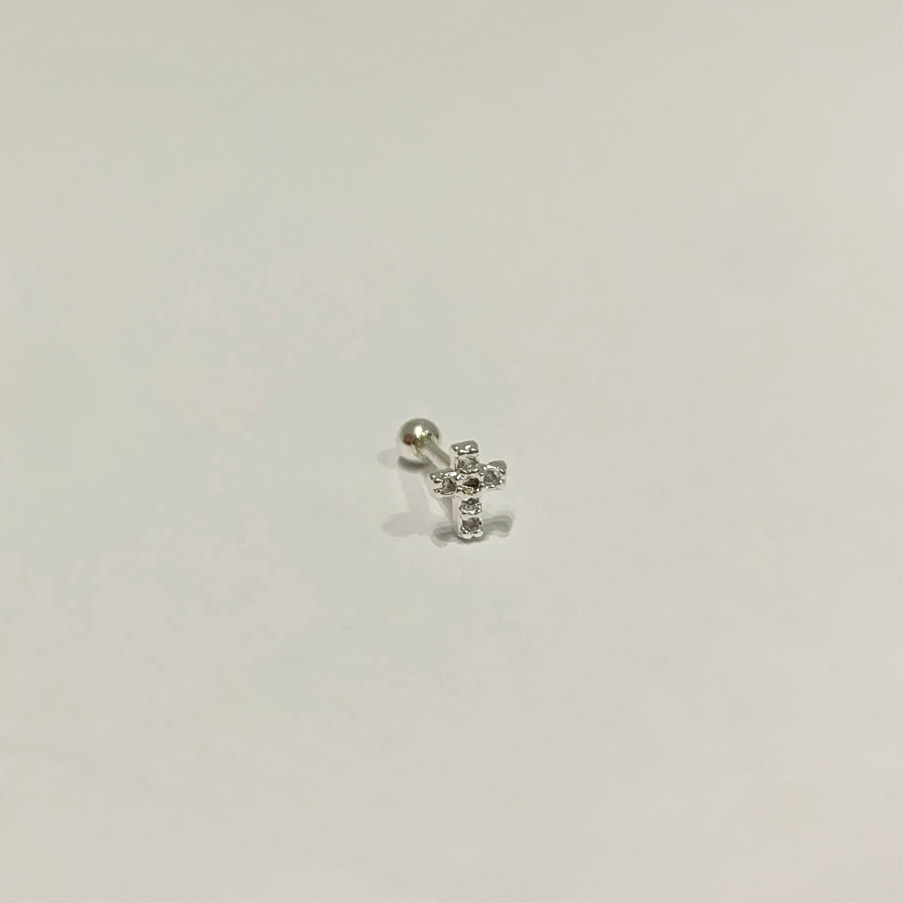 Piercing de furo cruz cravejada folheado a prata